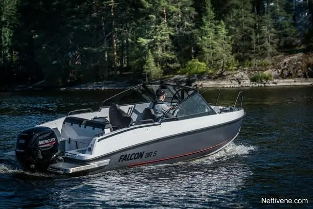 A Falcon BR 5 boat with a Mercury engine glides through calm waters, surrounded by lush green trees.